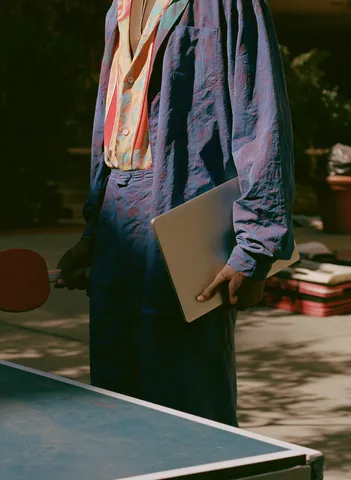 Membre Ballad Club avec laptop près d'une table de ping-pong