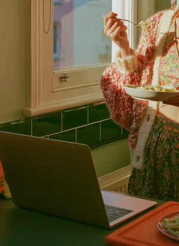 Membre Ballad Club déjeunant avec laptop ouvert